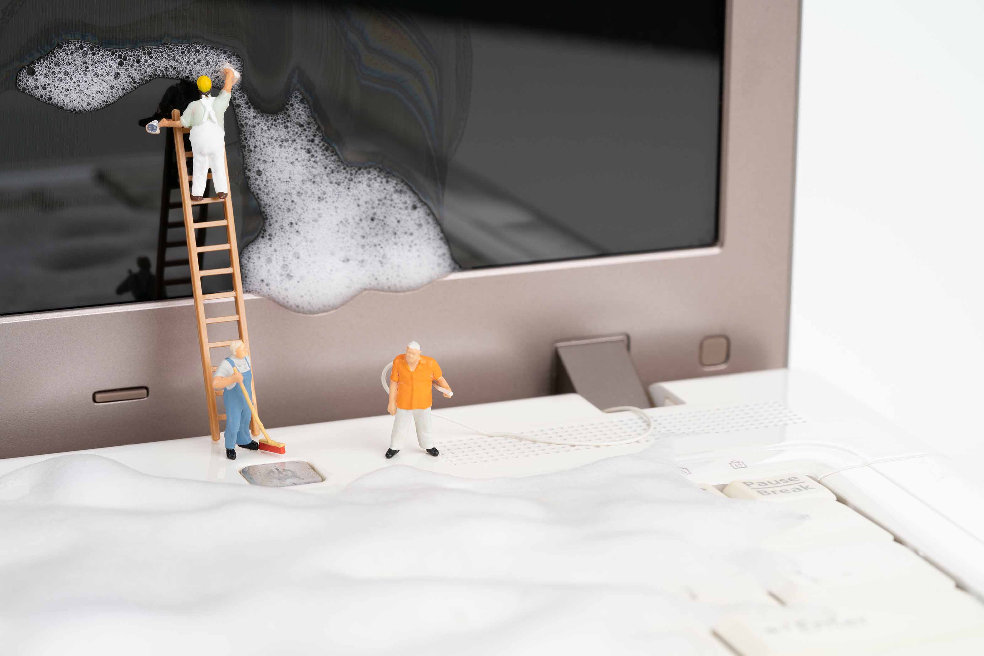 des petits personnages qui nettoient un écran d'ordinateur